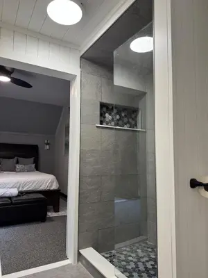 a glass door leading to a bedroom with a bed at Italy Inspired Lakeview Chalet with Hot Tub in Lake Harmony