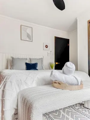 a white bedroom with a bed with a wooden tray on it at Italy Inspired Lakeview Chalet with Hot Tub in Lake Harmony