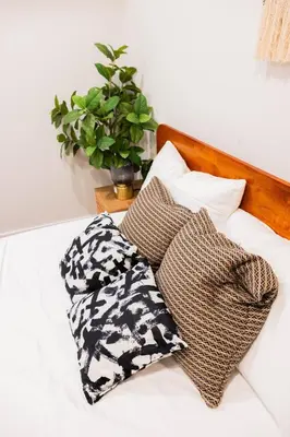 a bed with two pillows and a plant on it at Joynest Place in Newark