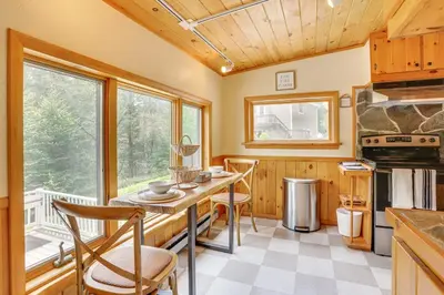 a kitchen with a table and chairs and a large window at 13 Mi to Ski Big Bear Updated Getaway with Deck in Shohola