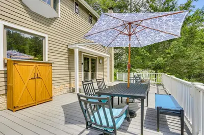 a patio with a table and chairs and an umbrella at 13 Mi to Ski Big Bear Updated Getaway with Deck in Shohola