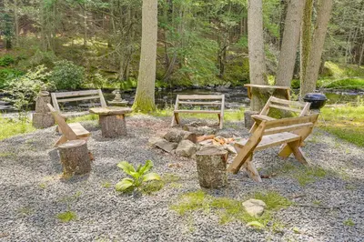 a group of benches and a fire pit in a park at 13 Mi to Ski Big Bear Updated Getaway with Deck in Shohola