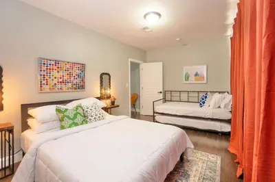 a bedroom with two beds and an orange curtain at The Hillside | Full House | Parking | Near EWR-NYC in Newark