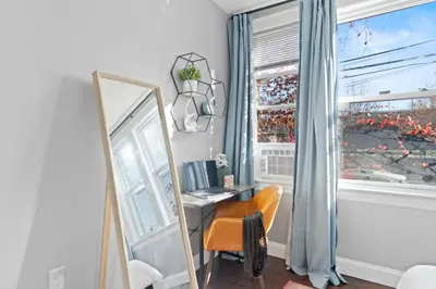 a mirror and a chair in a room with a window at Urban Charm | Near EWR Airport Easy Access to NYC in Newark