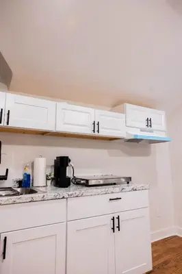 a kitchen with white cabinets and a counter top at Joynest Loft - Private Entry & Bath in Newark
