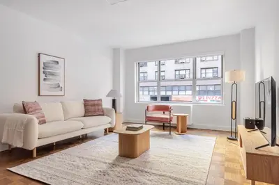 a living room with a couch and a tv at Blueground Midtown East doorman nr MoMA NYC-1786 in New York