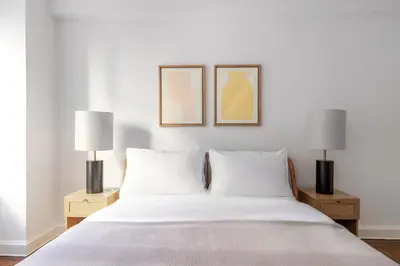 a bedroom with a white bed with two lamps at Blueground Midtown East doorman nr MoMA NYC-1786 in New York