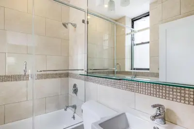 a bathroom with a shower and a sink and a mirror at Midtown Studio w Doorman Gym nr MSG NYC-143 in New York