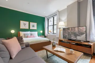a living room with a bed and a flat screen tv at Midtown Studio w Doorman Gym nr MSG NYC-143 in New York