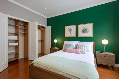 a bedroom with a green wall with a bed and two lamps at Midtown Studio w Doorman Gym nr MSG NYC-143 in New York