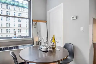 a dining room with a table and chairs and a window at Midtown Studio w Doorman Gym nr MSG NYC-143 in New York