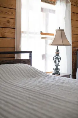 a lamp sitting on a table next to a bed at 5 min to Lake Chic Cozy Hot Tub in Sparta