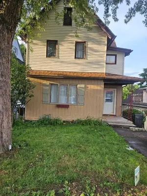 a yellow house with a tree in front of it at Super Comfy Entire Home in Scranton