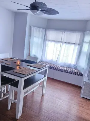 a dining room with a table and chairs and windows at Super Comfy Entire Home in Scranton