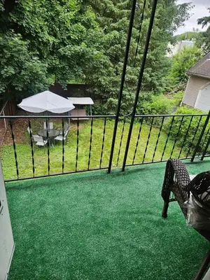 a fence with a table and an umbrella on a yard at Super Comfy Entire Home in Scranton