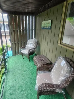a porch with two wicker chairs and a table at Super Comfy Entire Home in Scranton