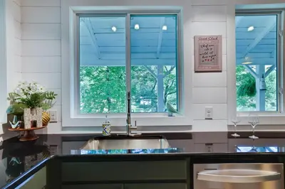 a kitchen with a sink and two windows at Heatherbell, A Lakeside Retreat in Saylorsburg