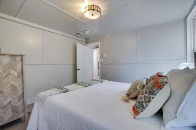a bedroom with a white bed with pillows on it at Heatherbell, A Lakeside Retreat in Saylorsburg