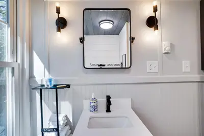 a bathroom with a white sink and a mirror at Heatherbell, A Lakeside Retreat in Saylorsburg
