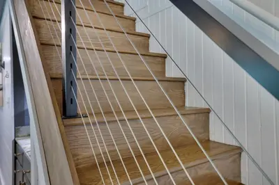 a wooden staircase with a metal railing in a room at Heatherbell, A Lakeside Retreat in Saylorsburg