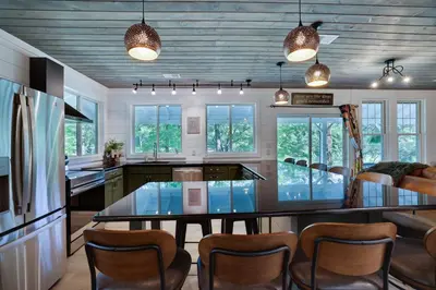 a kitchen with a glass table and chairs at Heatherbell, A Lakeside Retreat in Saylorsburg