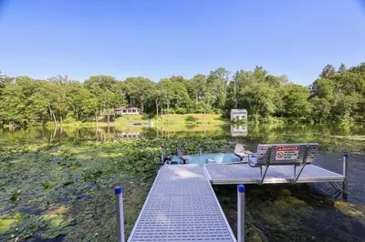 a dock on a lake with a bench on it at Heatherbell, A Lakeside Retreat in Saylorsburg