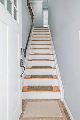 a stairwell with white walls and wooden treads at Cozy Home, 17 min from NYC, 2 Parking Spaces in Ridgefield Park