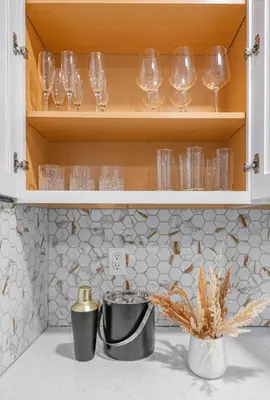 a kitchen counter with wine glasses in a cabinet at Cozy Home, 17 min from NYC, 2 Parking Spaces in Ridgefield Park