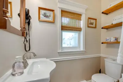 a bathroom with a sink and a toilet and a window at 6 Mi to Montage Mtn Resort! Family Home with Yard in Scranton