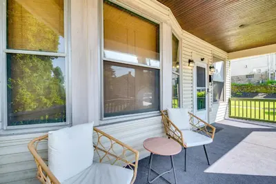 a porch with two chairs and a table and windows at 6 Mi to Montage Mtn Resort! Family Home with Yard in Scranton