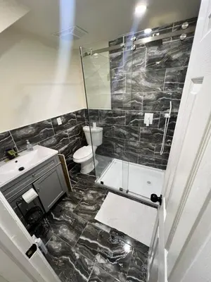 a bathroom with a shower and a toilet and a sink at Your Comfortable Home Away From Home in North Bergen