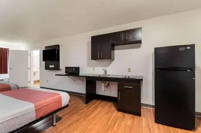a hotel room with a bed and a sink and a refrigerator at Motel 6 Wilkes Barre Arena in Wilkes-Barre