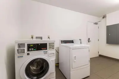 a laundry room with a washing machine and a tv at Motel 6 Wilkes Barre Arena in Wilkes-Barre