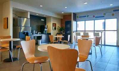a restaurant with chairs and tables and a kitchen at Motel 6 Wilkes Barre Arena in Wilkes-Barre