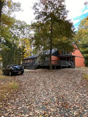 a house with a car parked in front of it at Paradise Uncovered Chalet Near Lake in Hawley