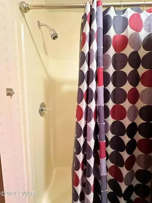 a shower curtain with a polka dot pattern in a bathroom at Paradise Uncovered Chalet Near Lake in Hawley