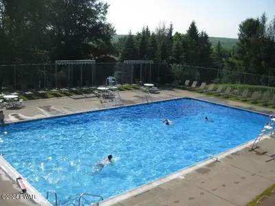 a group of people swimming in a large swimming pool at Paradise Uncovered Chalet Near Lake in Hawley