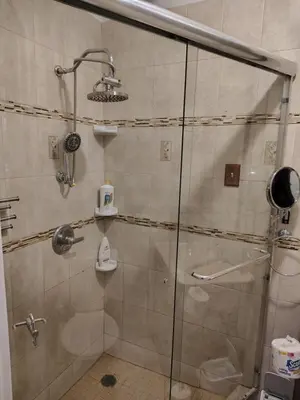 a shower in a bathroom with a glass door at Cozy apartment in Brooklyn