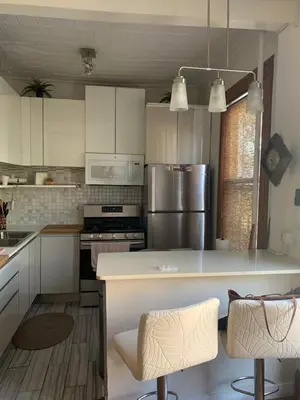 a kitchen with white cabinets and stainless steel appliances at Cozy apartment in Brooklyn