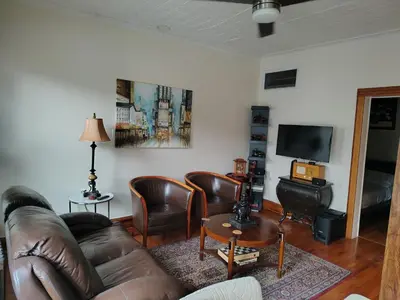 a living room with a leather couch and chairs at Cozy apartment in Brooklyn