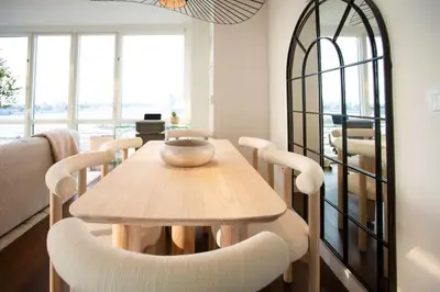 a dining room with a wooden table and chairs at Modern Designer Stunning Hudson Views Corner Unit in New York