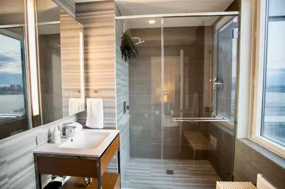 a bathroom with a sink and a shower at Modern Designer Stunning Hudson Views Corner Unit in New York