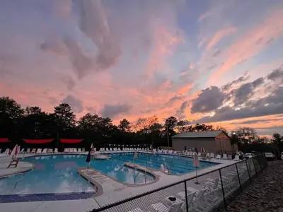 a large swimming pool with a sunset in the background at Cozy 4-Season Chalet w Arcades & Lake, Ski Lifts in Lackawaxen