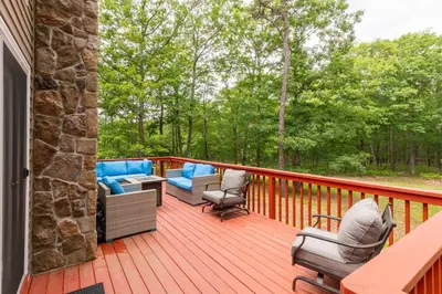 a deck with couches and chairs on a porch at Cozy 4-Season Chalet w Arcades & Lake, Ski Lifts in Lackawaxen