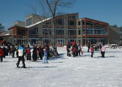 a group of people standing in the snow in front of a building at Cozy 4-Season Chalet w Arcades & Lake, Ski Lifts in Lackawaxen