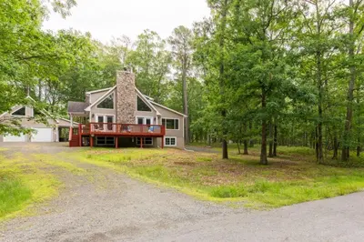 a house in the woods with a driveway at Cozy 4-Season Chalet w Arcades & Lake, Ski Lifts in Lackawaxen