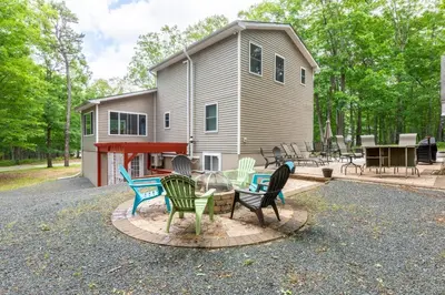 a group of chairs sitting around a table in front of a house at Cozy 4-Season Chalet w Arcades & Lake, Ski Lifts in Lackawaxen
