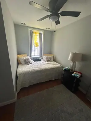 a bedroom with a bed with a ceiling fan and a window at Theres No Place Like Home in Philadelphia