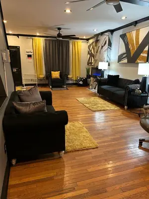 a living room with black couches and rugs at Theres No Place Like Home in Philadelphia