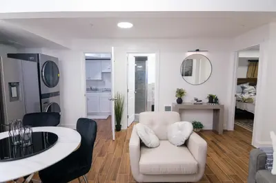 a living room with a white chair and a table at BrightOAK Eloire-Private in Newark